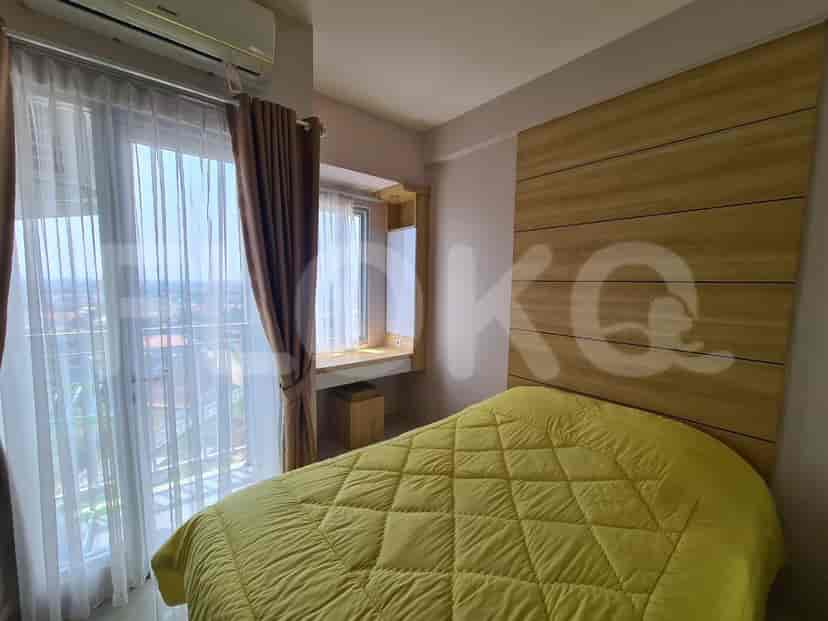 Bedroom with a large window, wooden paneling, and a yellow quilt.