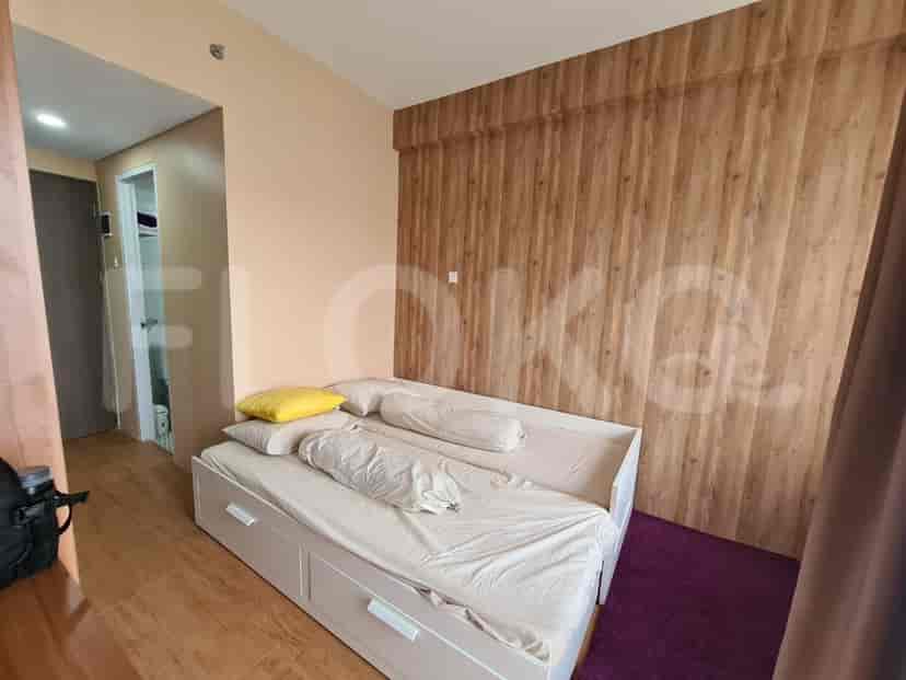 A cozy bedroom with a pull-out bed and a wood-paneled wall.