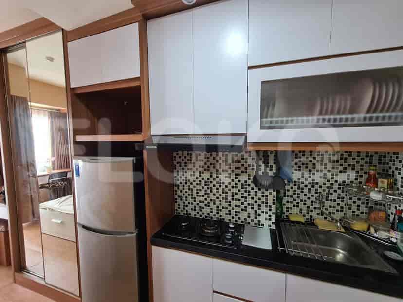 A modern and compact kitchen featuring stainless steel appliances and black countertop.