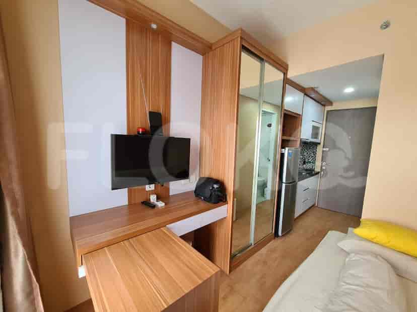 A well-designed space with a desk, bed, and kitchen.