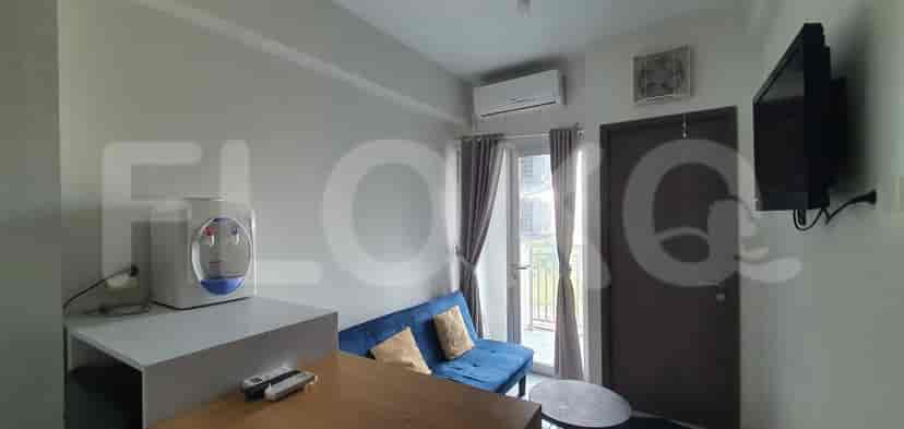 A modern living space with a blue sofa, dining area, and access to a balcony.
