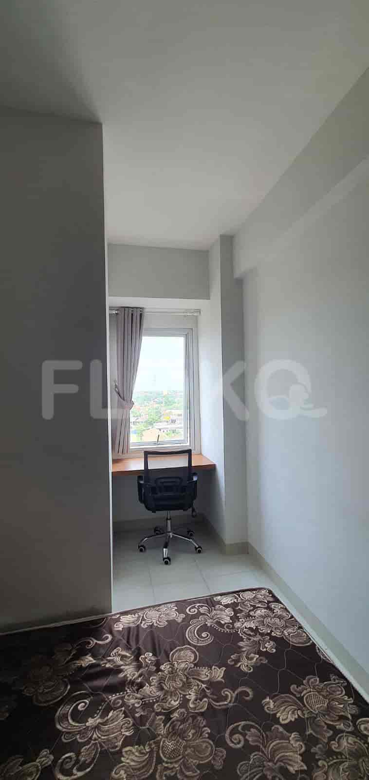 Bedroom with a bed, desk, and access to a balcony.