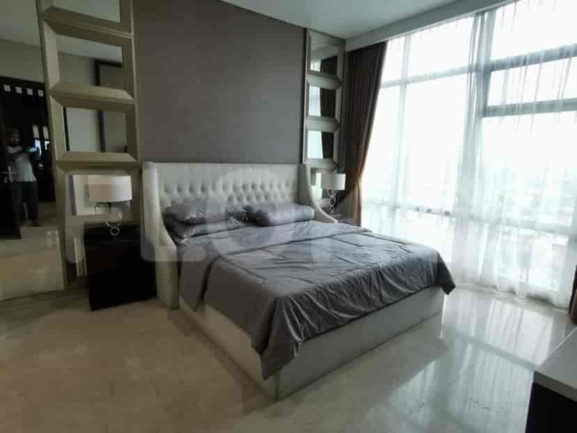 A master bedroom with a large bed and large windows.