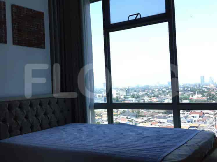 Bedroom with a large window, bed, and artwork.