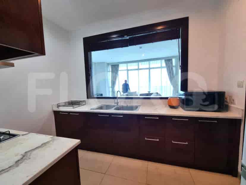 A kitchen with a sink, microwave, and a view.
