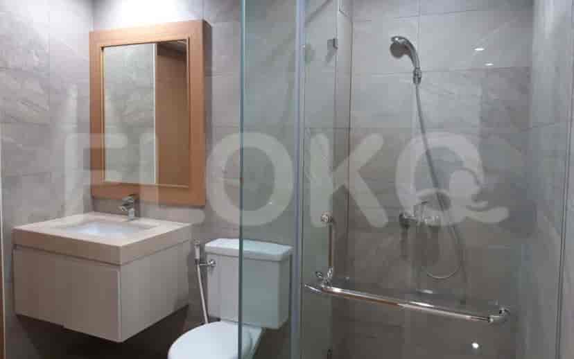 Kamar mandi dengan shower kaca dan wastafel.