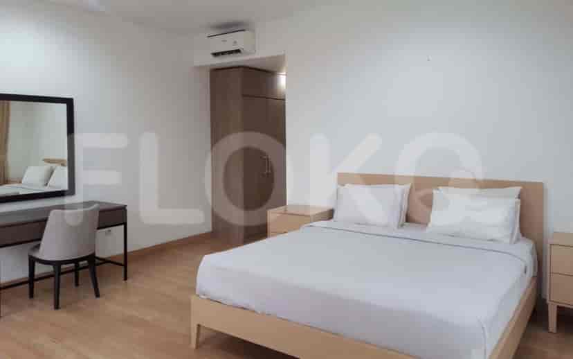 Sebuah kamar tidur dengan tempat tidur double, meja rias, dan cermin besar.