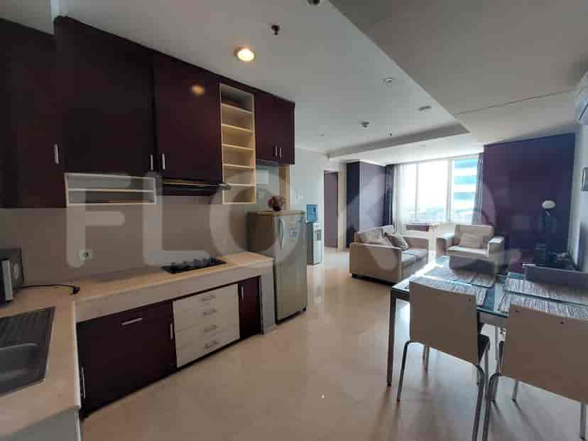A well-equipped kitchen with dark brown cabinets, a marble countertop, and a refrigerator.