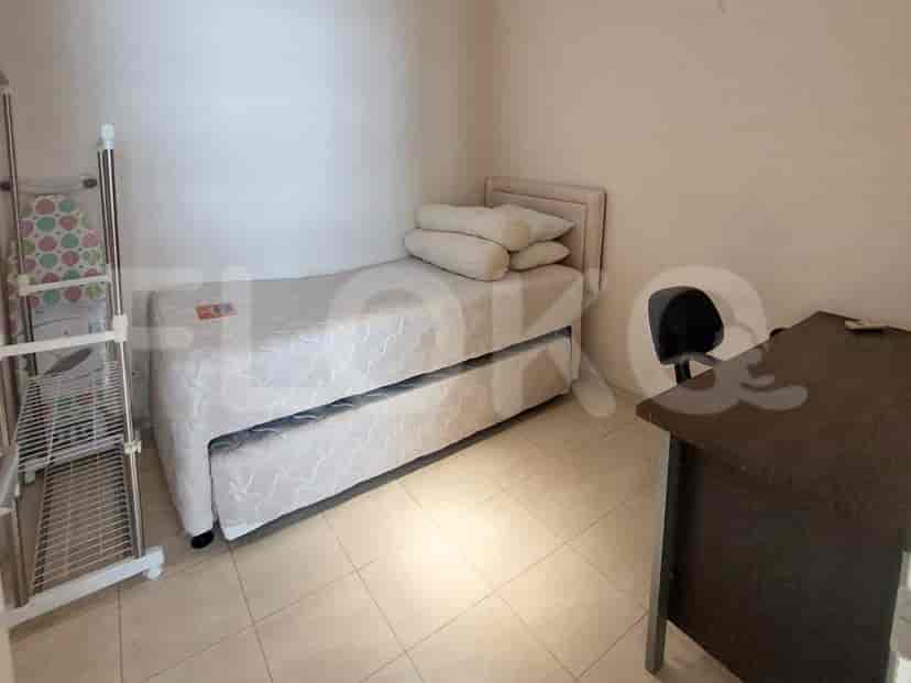 A small bedroom with a bed and a desk.