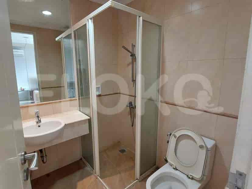 A modern bathroom with a glass shower, toilet, and sink.