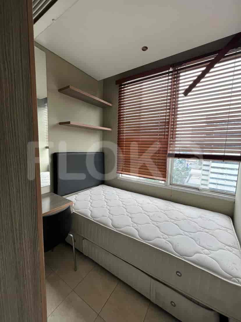 A small bedroom with a single bed and wooden blinds.