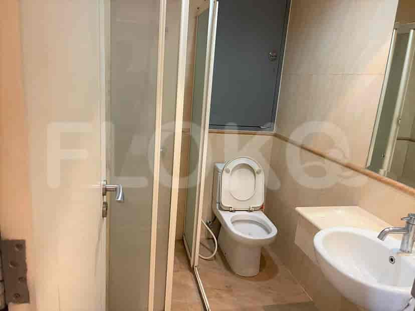 A small bathroom with a toilet, sink, and a shower enclosure.