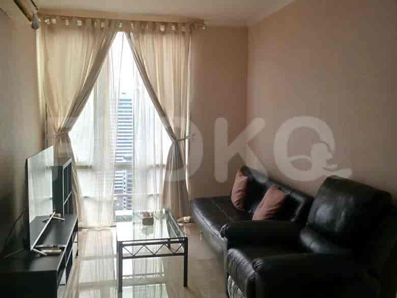 A dining area with a glass table and four chairs.