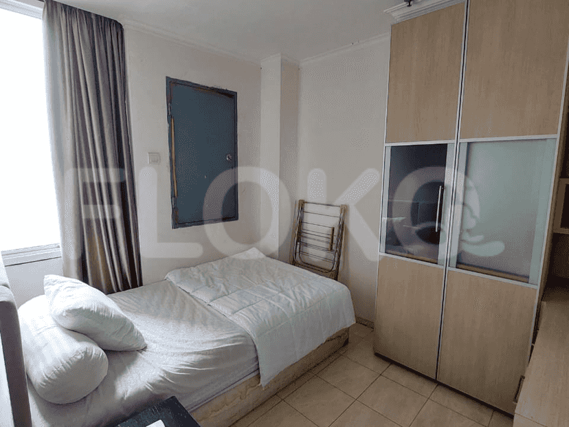 A bedroom with a single bed, wardrobe, and simple decor.