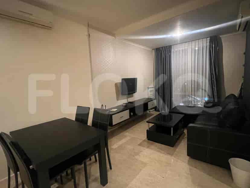 Living room with a dining table, TV, and black leather sofa.