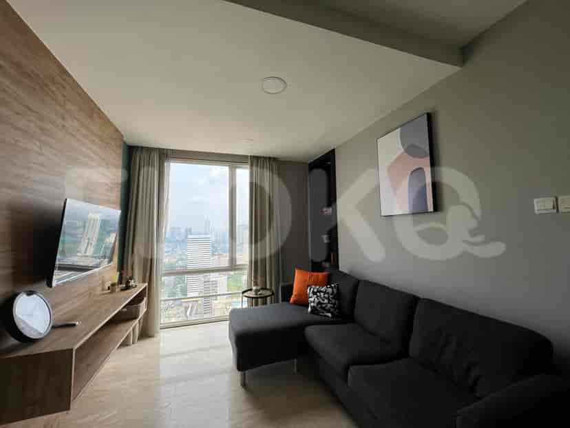 Living room featuring a sectional sofa, smart TV, and a view of the city through a large window, combined with a fully equipped kitchen.