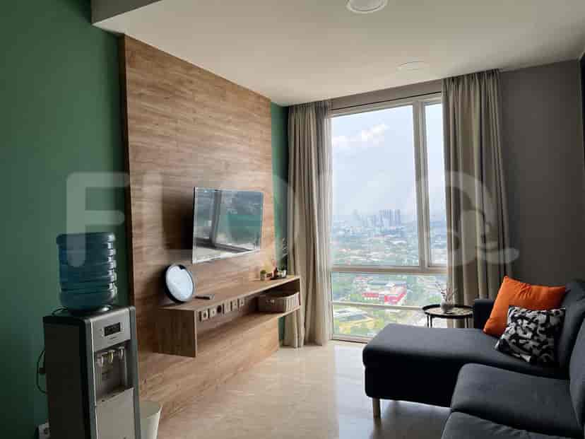 Spacious living room showcasing a modern entertainment unit, sofa, and the vibrant city view.