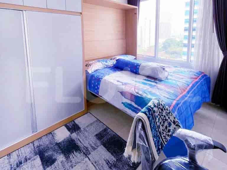 A small bedroom with a wall-mounted bed, a large closet, and a city view.