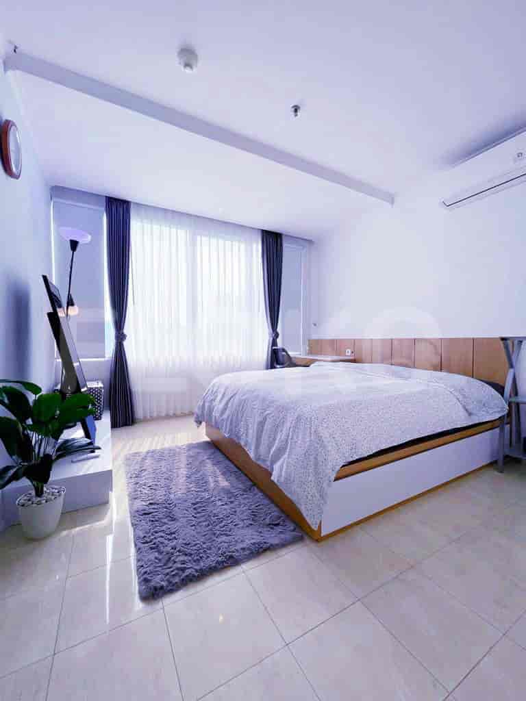 A cozy bedroom with a queen-sized bed, curtains, and an AC unit.