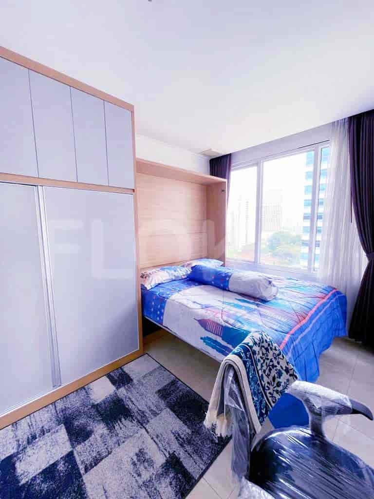 A bedroom with a murphy bed, sliding closet doors, and a view.