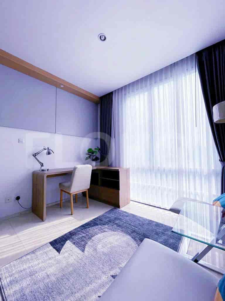 A modern home office with a desk, chair, and storage cabinet.