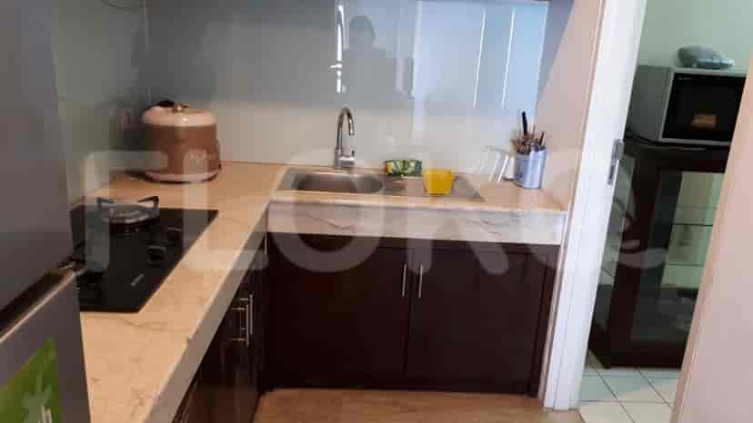 A kitchen with sink, stove, and cabinets.
