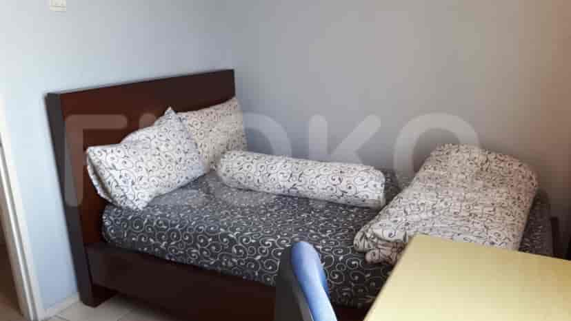 A small bedroom with a dark wood bed and patterned bedding.
