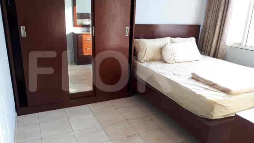 Bedroom with a dark wooden bed, wardrobe, and mirror.