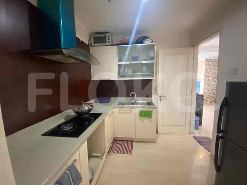 A modern kitchen with white cabinets, a gas stove, and a stainless steel sink.