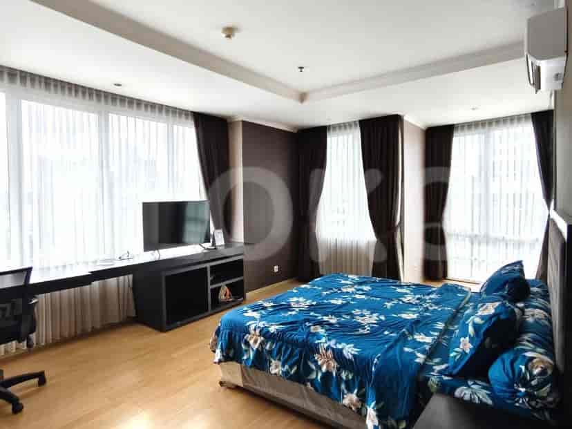 Kamar tidur utama dengan tempat tidur ukuran king dan TV.