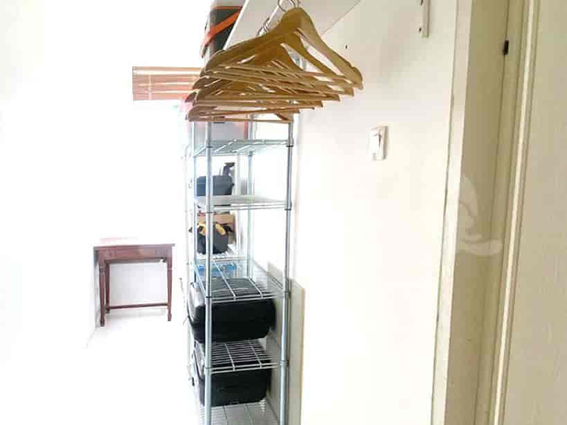 Hallway with a storage rack and other storage.