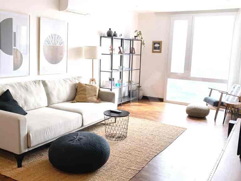 Modern living room with a grey sofa, artwork, and a stylish rug.