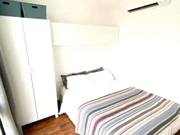 Bedroom with a double bed, a wardrobe, and storage above.