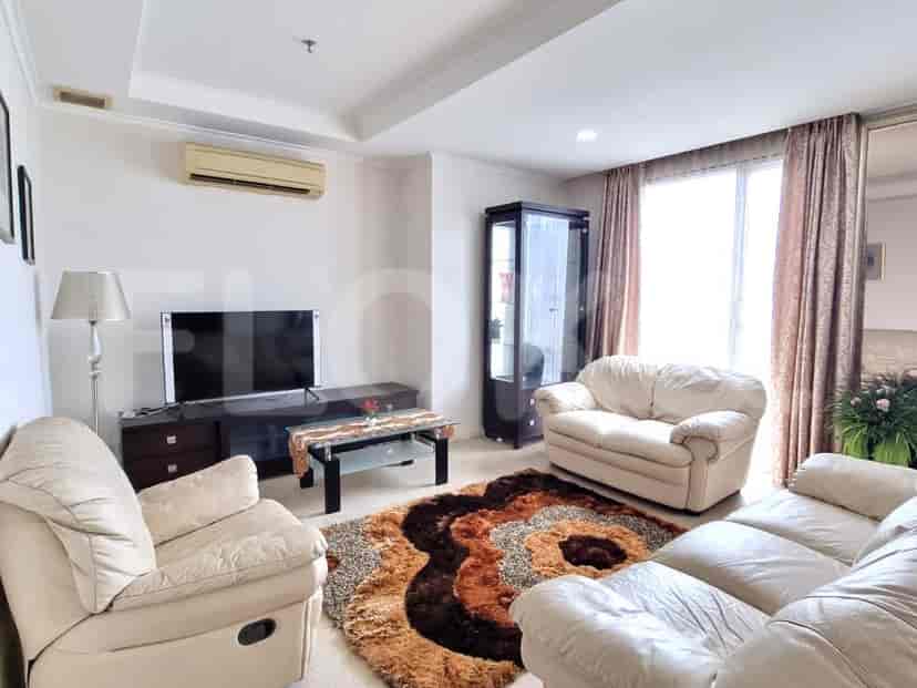 A well-lit living room with a sofa, TV, and entertainment unit.