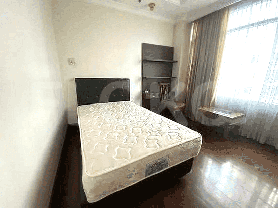 Bedroom with a single bed, desk, and shelving unit.