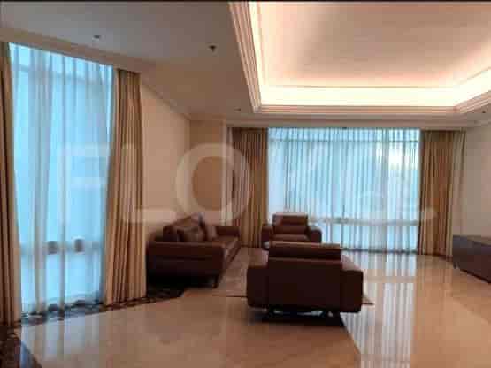 Spacious living room with a brown sofa, armchairs, and large windows with curtains.