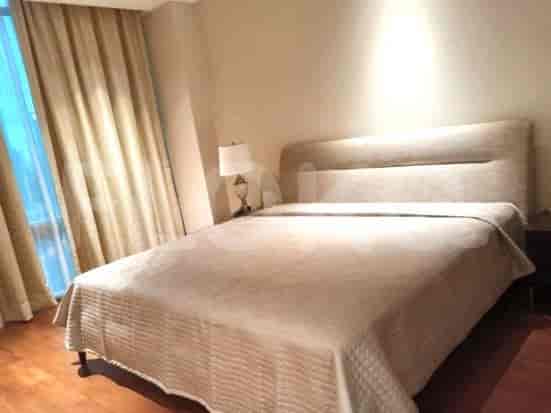 Bedroom featuring a bed, table lamp, and window with curtains.