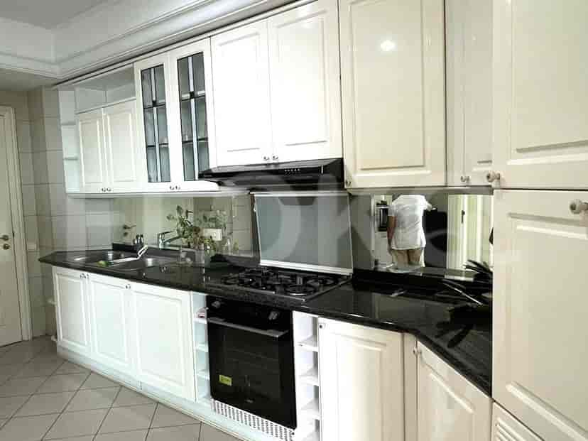 A modern kitchen with white cabinets, a black countertop, and a gas stove.
