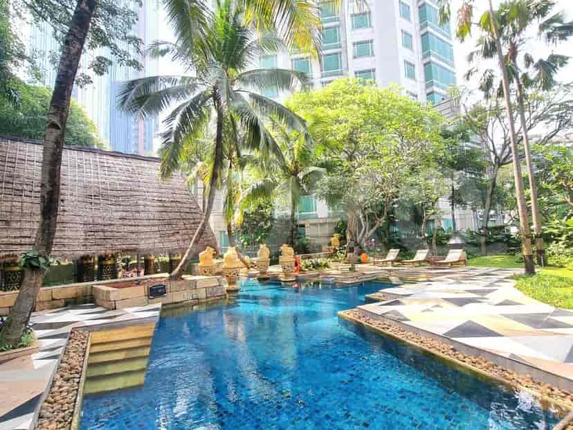 Swimming pool with a hut and lounge chairs.