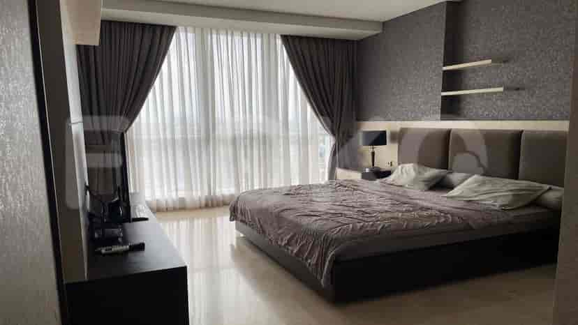 Bedroom with a large bed, curtains, and a TV.