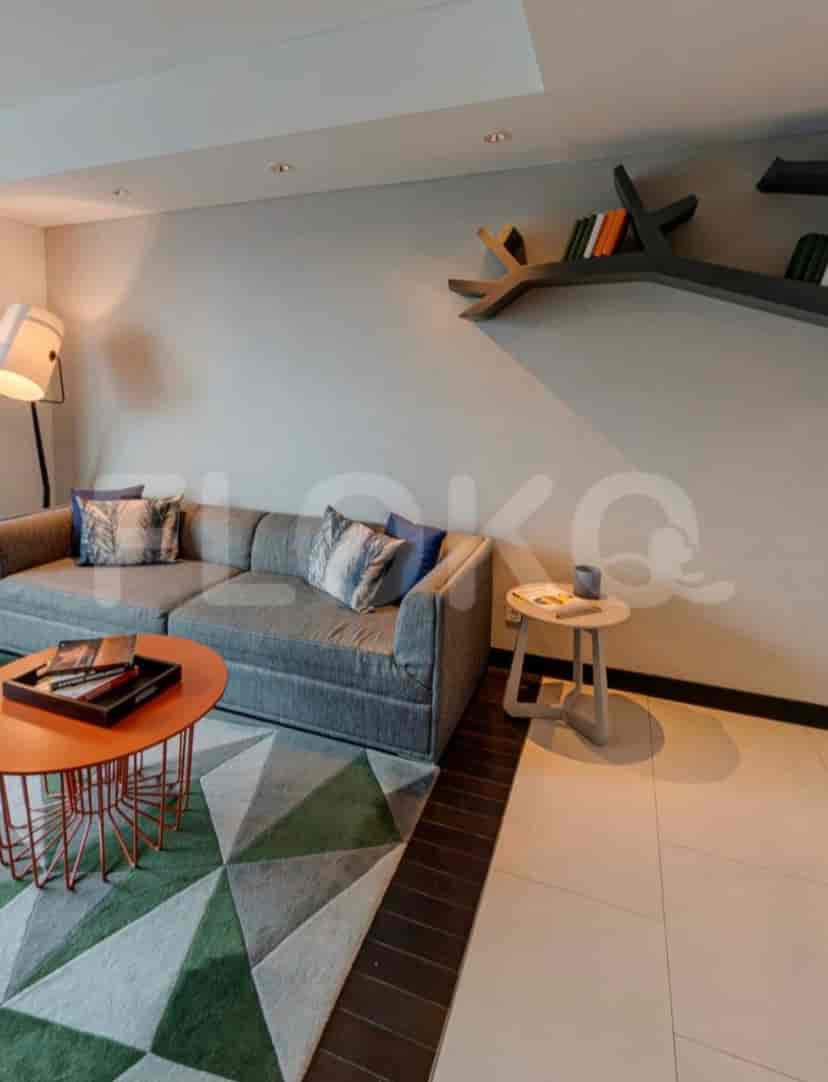 Living room with grey sofa, coffee tables, and tree-shaped bookshelf.