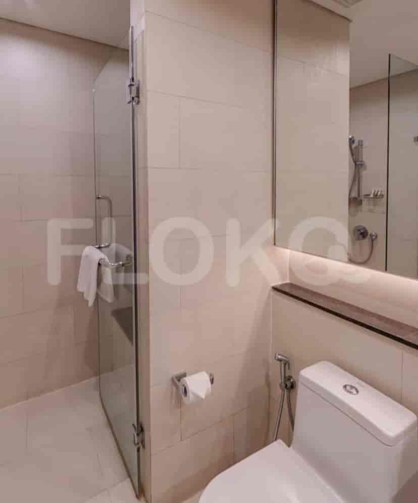 Bathroom with a toilet, shower, and mirror.