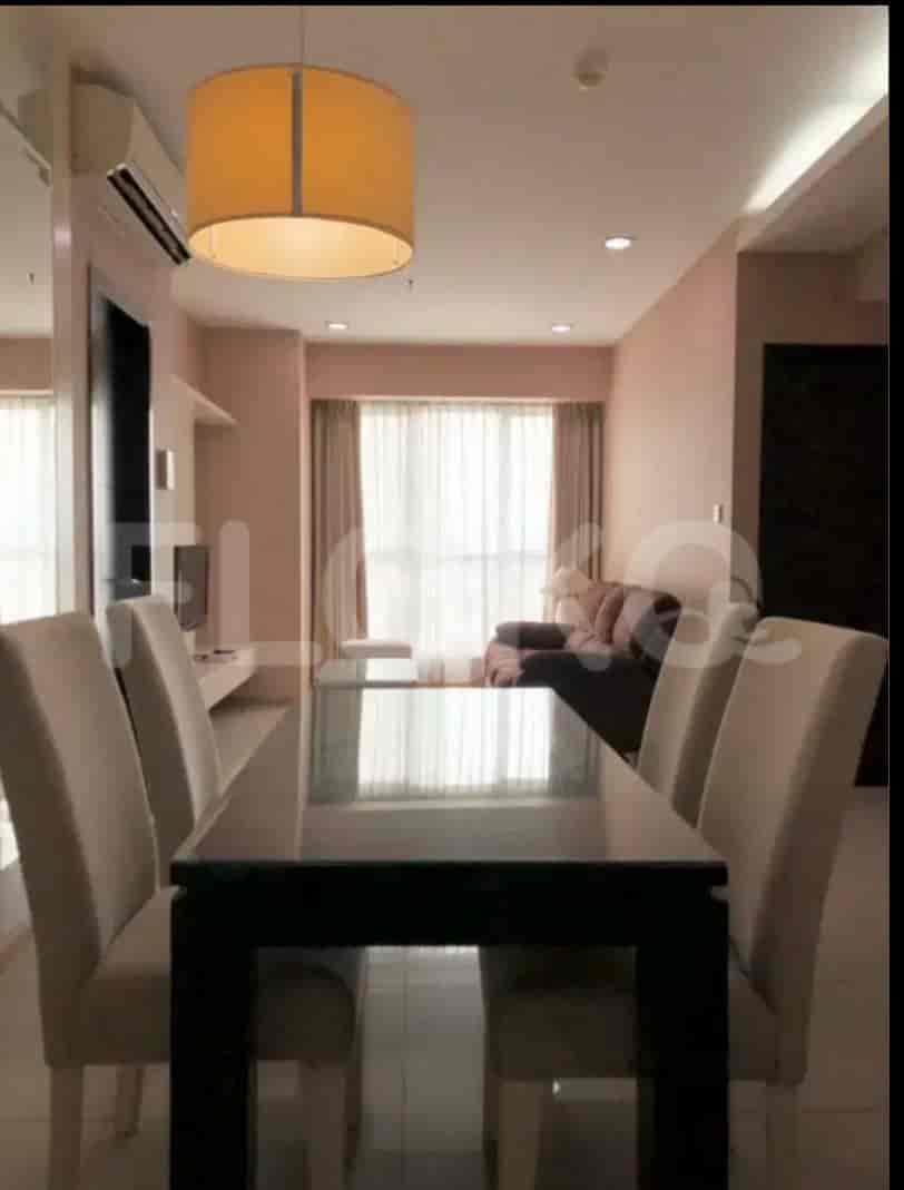 A dining area with a black dining table and cream-colored chairs.