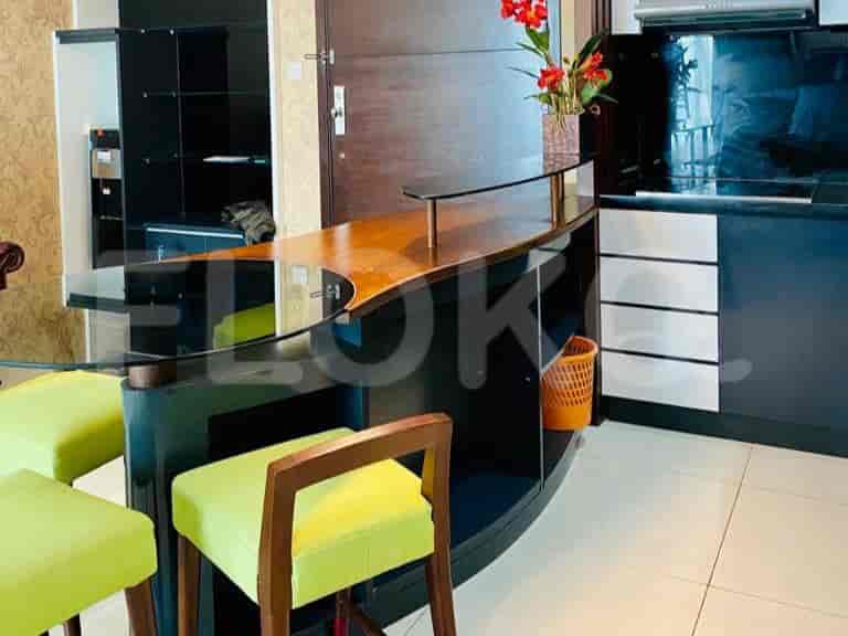 A kitchen with a breakfast bar and stools, featuring a dark wood and black finish.