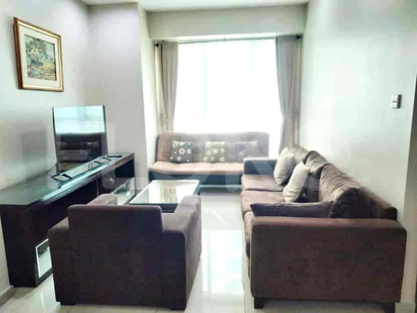 Living room with a sofa set, wall-mounted TV, and a large window.