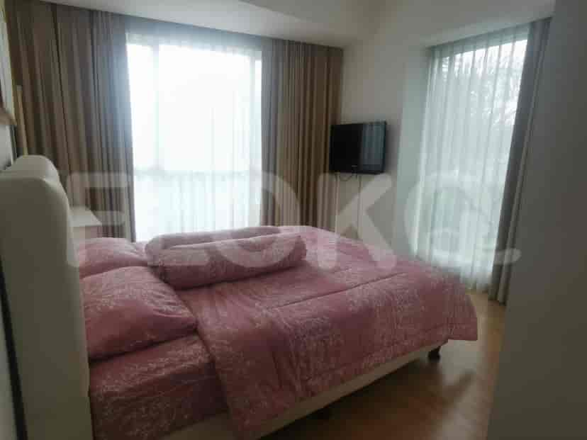 Bedroom with a pink bedspread and window.