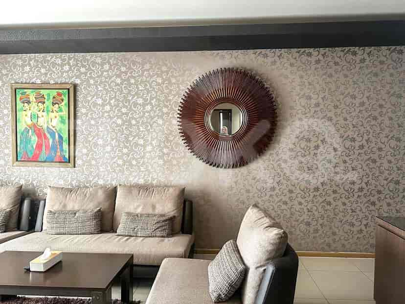 The living room with the sofa, a mirror, and a circular mirror.