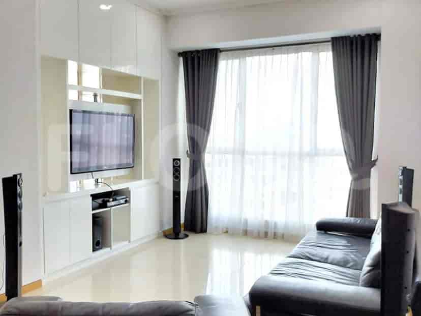 Modern living room with a built-in entertainment unit, TV, and large window.