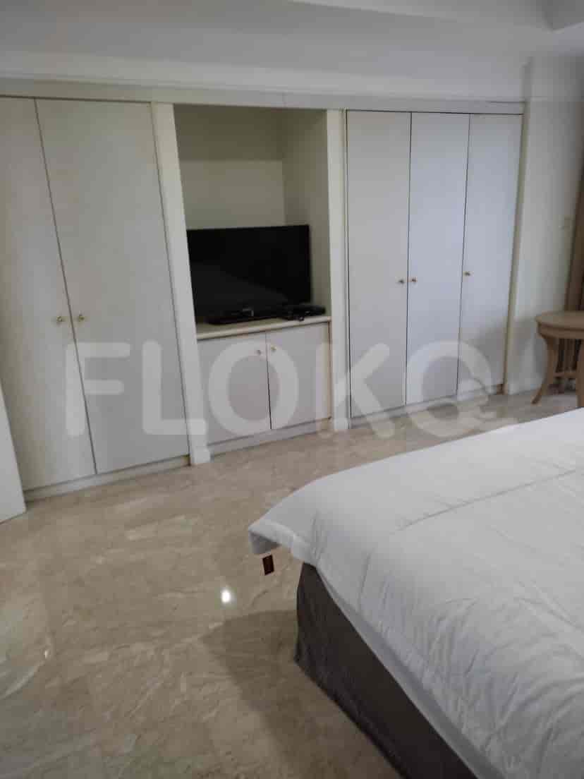 Bedroom with wardrobe, TV and bed.