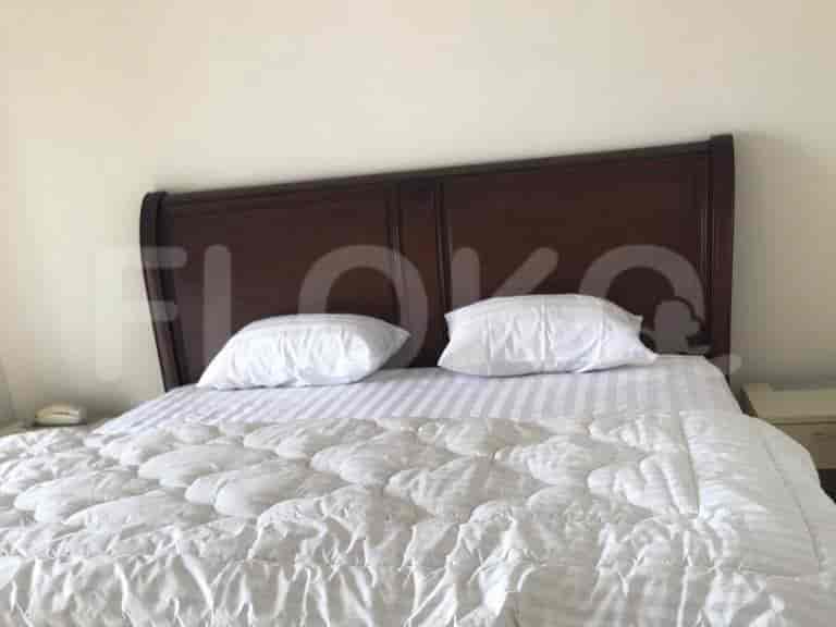 Kamar tidur utama dengan kepala tempat tidur kayu besar.